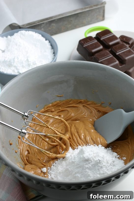 We're slowly adding in the powdered sugar so the peanut butter batter will thicken up, forming the delicious middles of our chocolate peanut butter eggs.