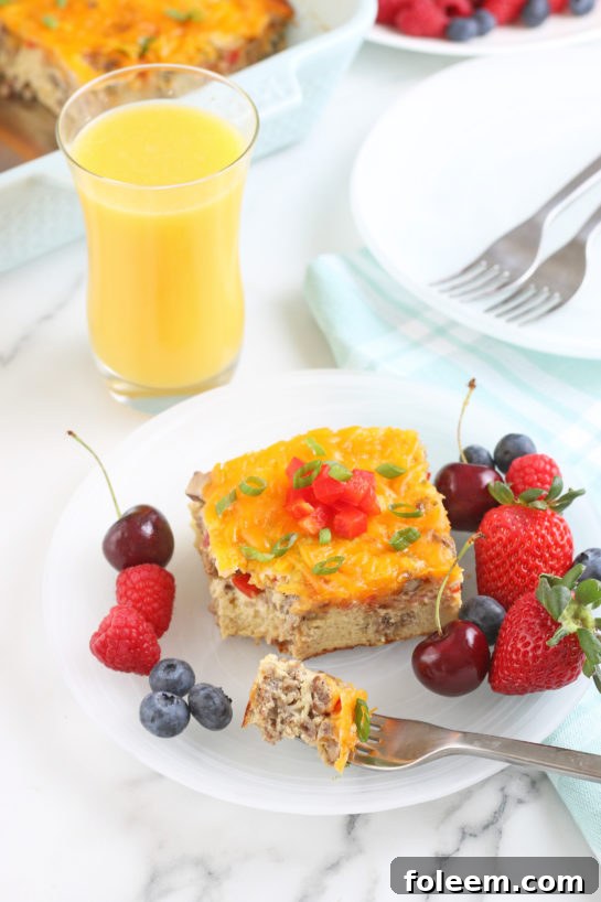 When we take a step back we see the casserole served up on a plate with fruit and a glass of orange juice.