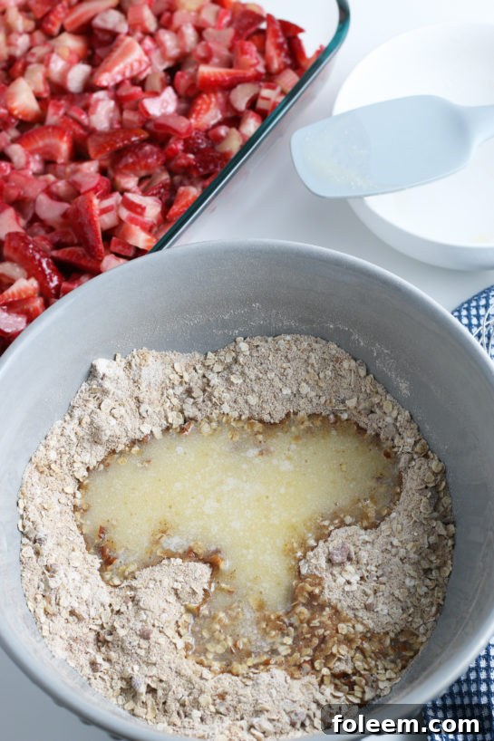 Adding the wet ingredients for Strawberry & Rhubarb crisp dessert recipe