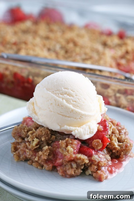 Strawberry & Rhubarb crisp recipe finished in the pan and out of the oven and plated with ice cream on top