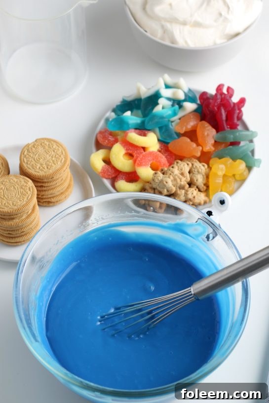 Adding the blue jello mix to the bowl to make beach sand pudding cups recipe