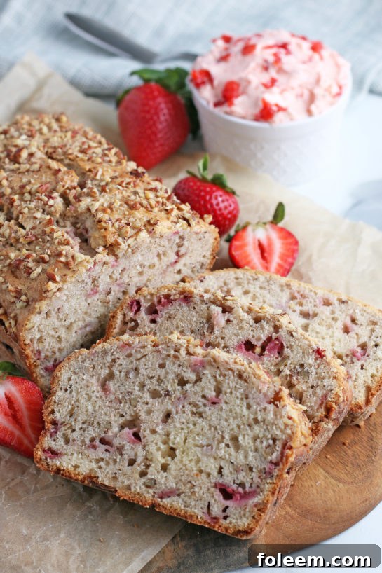 A close-up shot of several slices of incredibly moist strawberry bread, showcasing the vibrant strawberry pieces and rich, tender crumb, ready to be enjoyed.