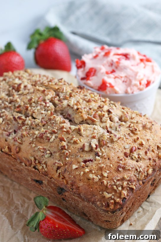A glorious view of the entire, freshly baked loaf of strawberry bread, golden-brown and perfectly risen, awaiting its first slice.