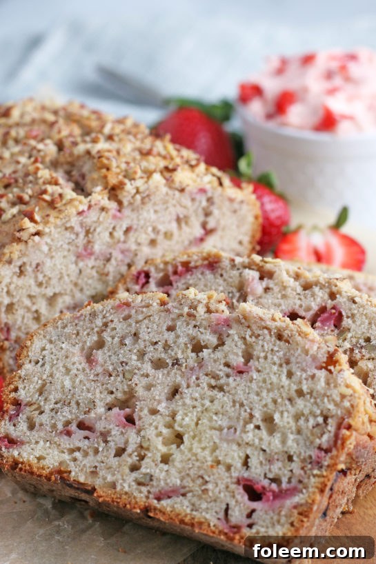 Another mouthwatering close-up of a sliced strawberry bread, showcasing its inviting texture and ready to be served and enjoyed by all.