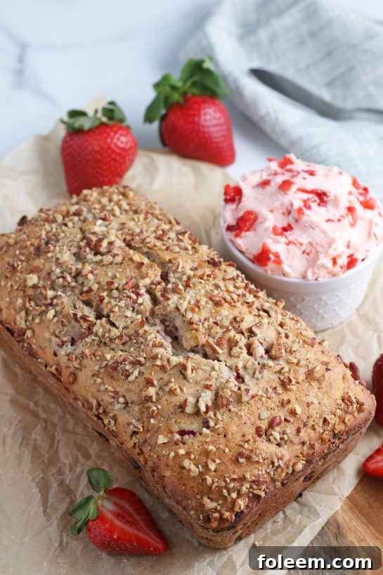 The full loaf of golden-brown strawberry and cream bread, perfectly baked and ready to be sliced, garnished with a sprinkle of powdered sugar for an elegant finish.