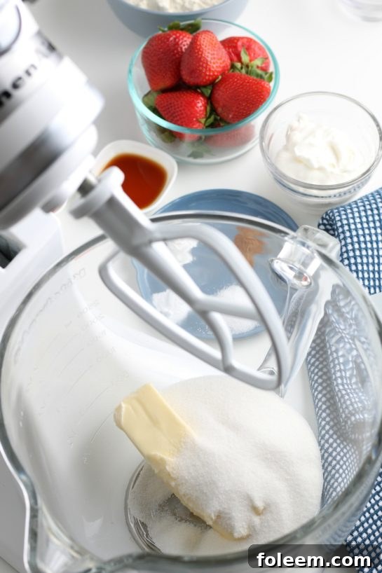 A vibrant view inside the stand mixer, with the first wet ingredients starting to combine, marking the beginning of our strawberry bread batter.