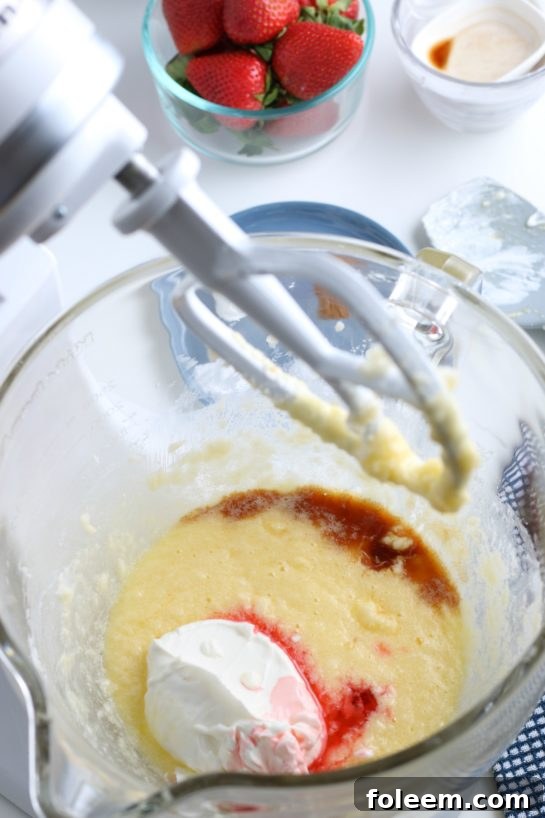 More essential ingredients are being incorporated into the stand mixer, building the rich batter for our exceptional strawberry and cream bread.