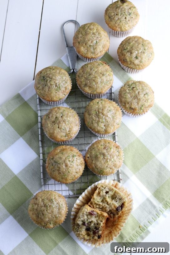 Overhead shot of freshly baked Zucchini Muffins, arranged on a cooling rack, highlighting their golden-brown tops and inviting texture. Spiced with cinnamon, these muffins are a delightful way to enjoy fresh zucchini.