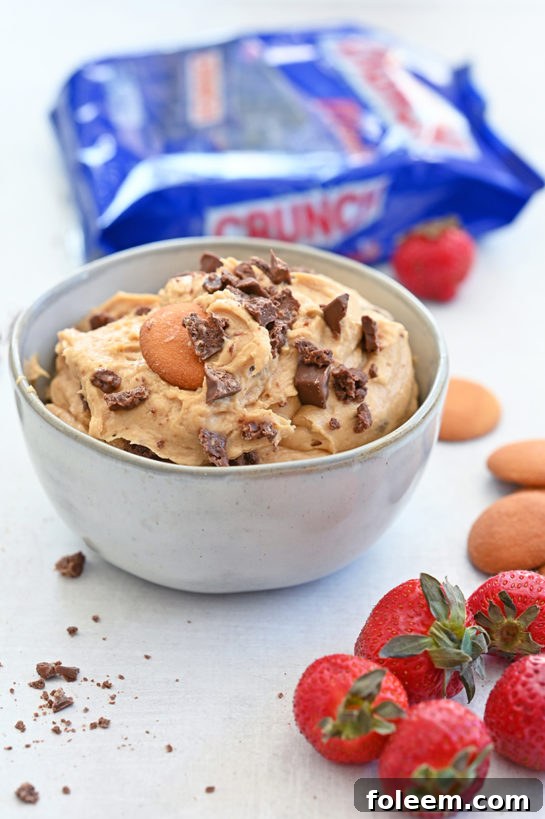 Indulgent Peanut Butter Crunch Bar Dip is a sweet dunkable dessert dip recipe that's perfect for parties and made in less than 10 minutes. Slice up an apple and dig in!