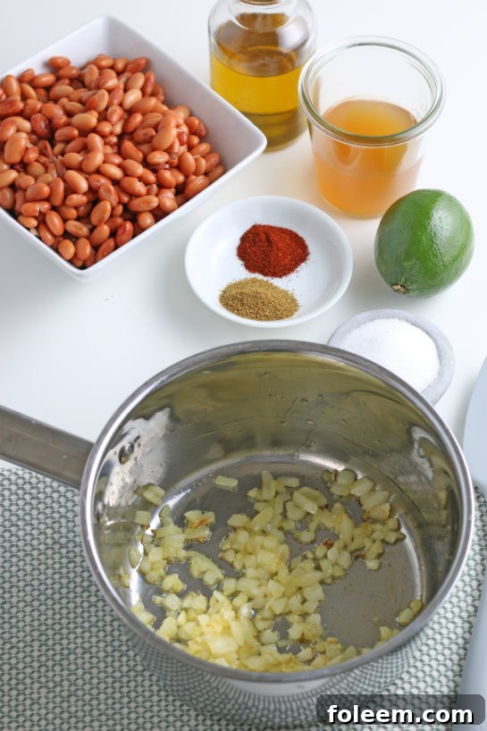 Finely chopped onions sizzling in olive oil in a pan, the first step for delicious refried beans.