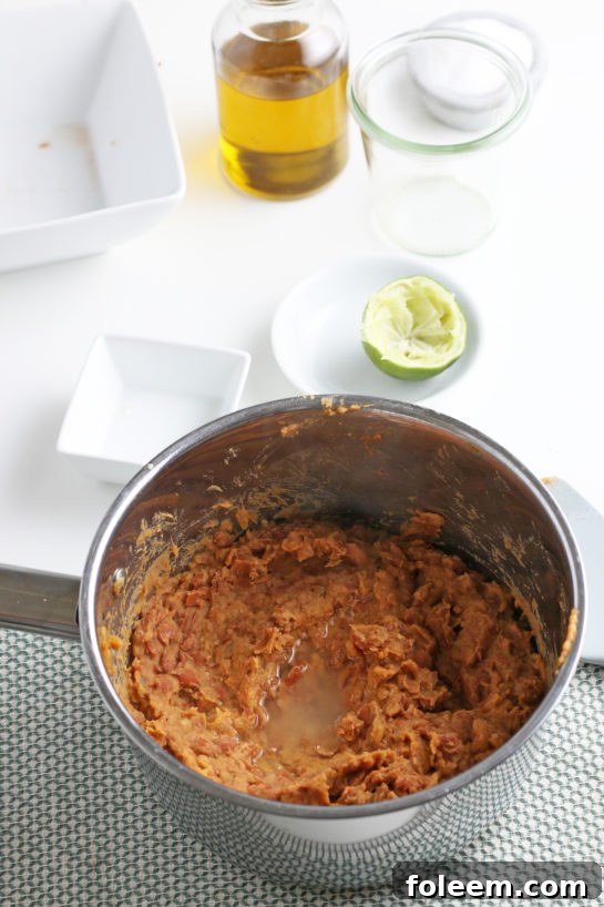 Overhead view of perfectly mashed pinto beans, showcasing their ideal creamy texture for refried beans.
