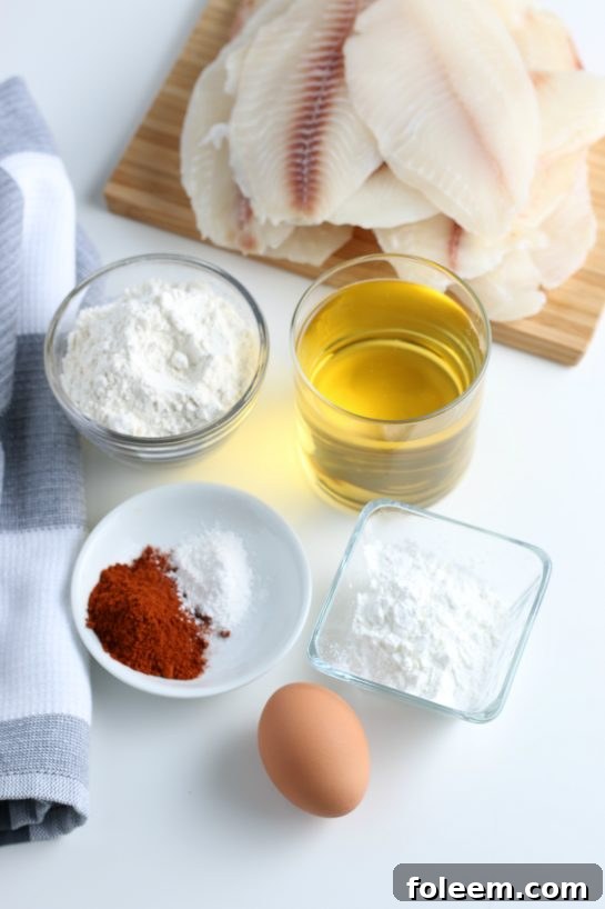 Arrangement of fresh ingredients including white fish, flour, spices, and limes, prepared for making Baja Fish Tacos