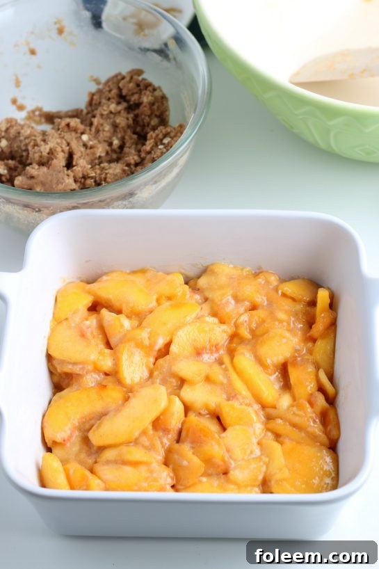 Adding the prepared peach filling into the buttered baking pan