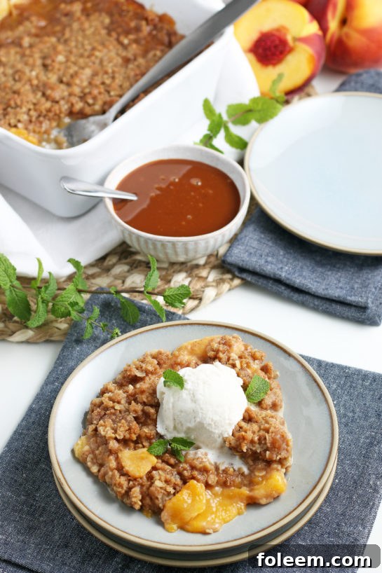A stunning shot of the baked fresh peach crisp with golden topping and bubbly peach filling