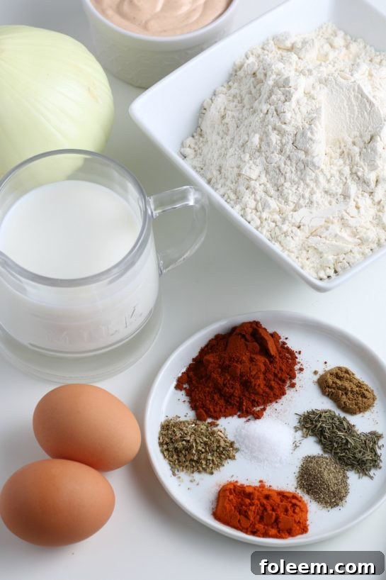 A selection of fresh ingredients laid out for making the fried blooming onion recipe, including a large sweet onion, flour, and spices.