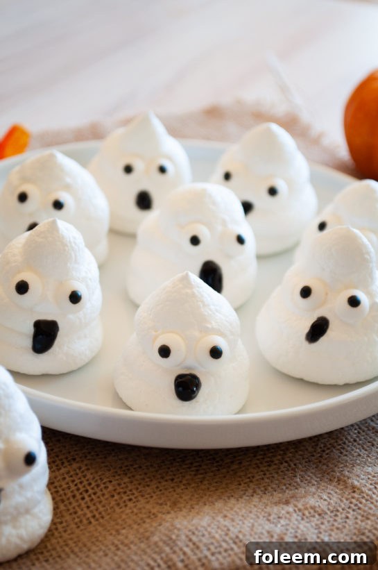 Fluffy and crispy Halloween Boo Meringues shaped like adorable ghosts, perfect for a party dessert.
