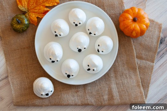 Overhead shot of a platter of freshly baked Halloween Boo Meringues, ready for decorating.