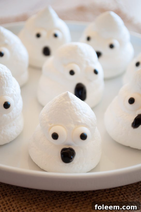 A close-up of a finished Halloween Boo Meringue, showcasing its adorable ghost shape and decorated eyes, ready for a party.