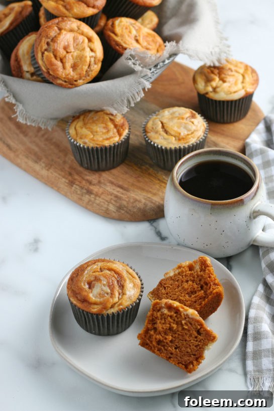 Close-up of a Pumpkin Cream Cheese Swirl Muffin, showing the beautiful intricate swirl pattern on top, ready for a fall, Halloween, or Thanksgiving celebration.