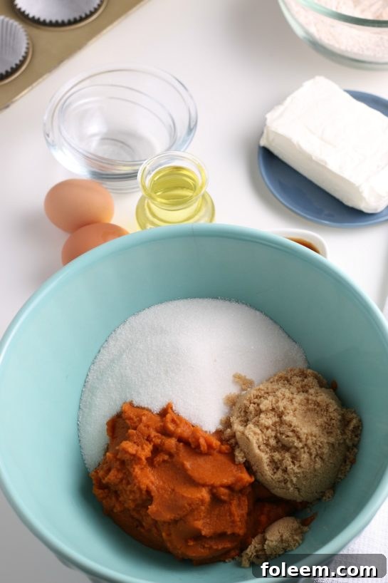 Adding rich, orange pumpkin puree to the bowl of dry ingredients, ready for mixing into the muffin batter.