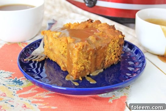 Close-up of a delectable serving of Crock Pot Pumpkin Bread Pudding with a spoonful of warm caramel.