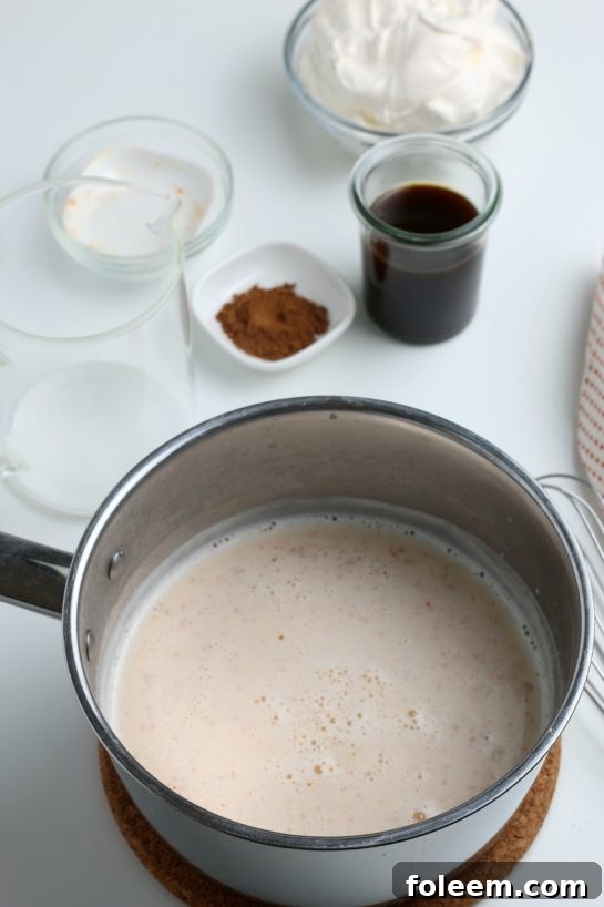 Pouring fresh whole milk into the saucepan, the base for a rich and creamy Homemade Pumpkin Spice Latte