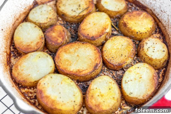 Oven-baked skillet of melting potatoes removed from the oven, still sizzling