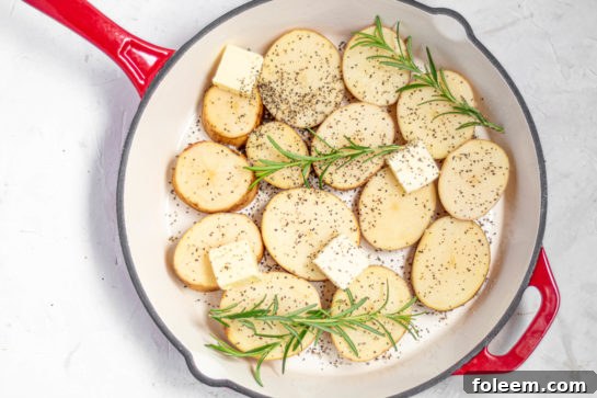Unsalted butter melting in a hot oven-safe skillet, preparing for the potatoes