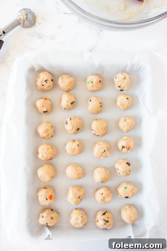 Scooping out the dough and adding to the baking tray for Edible Cookie Dough Bombs recipe