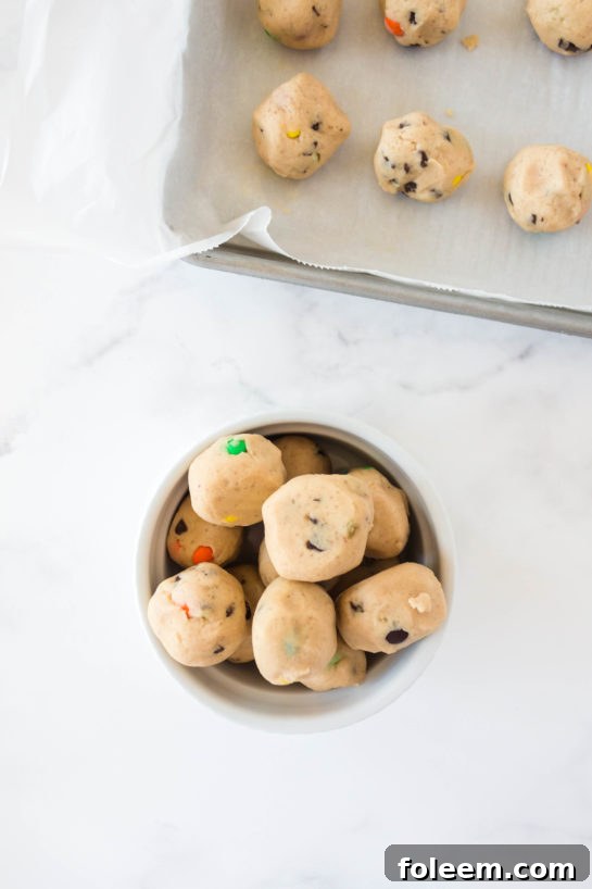 The dough balls reading to be dipped in the white chocolate for Edible Cookie Dough Bombs recipe