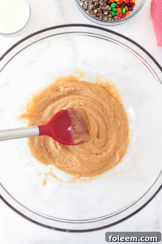 Adding the wet ingredients to the dry ingredients needed for Edible Cookie Dough Bombs recipe