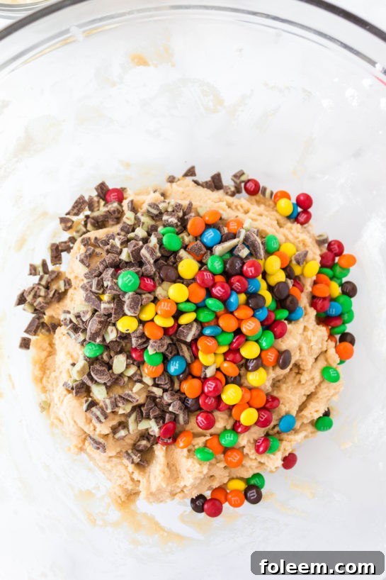 Adding the candy needed for Edible Cookie Dough Bombs recipe