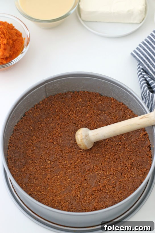 Pressing the crust into the springform pan for the No Bake Pumpkin Cheesecake recipe