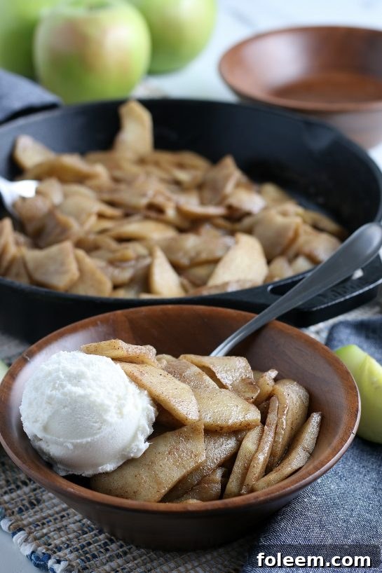 A skillet filled with beautifully browned, tender fried apples, glistening with butter and cinnamon. Ready to be served.