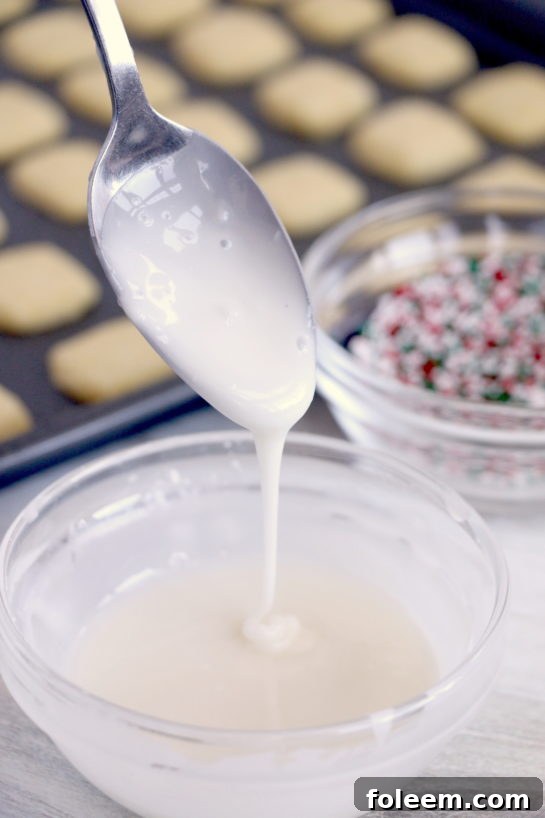 Preparing the smooth, sweet icing in a bowl, perfect for drizzling over the cooled cookie bites.