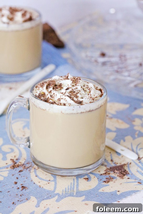 Individual glass of creamy coffee punch with whipped cream and chocolate shavings.