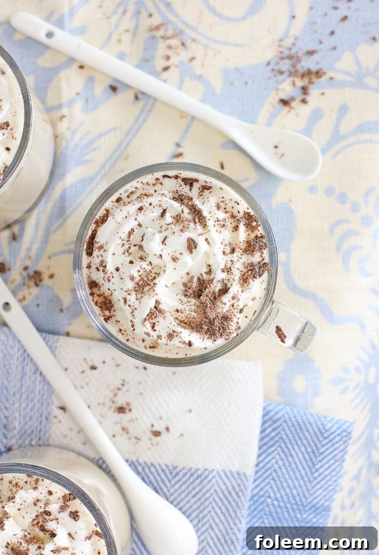 Close-up of frothy coffee punch in a clear punch bowl, garnished.