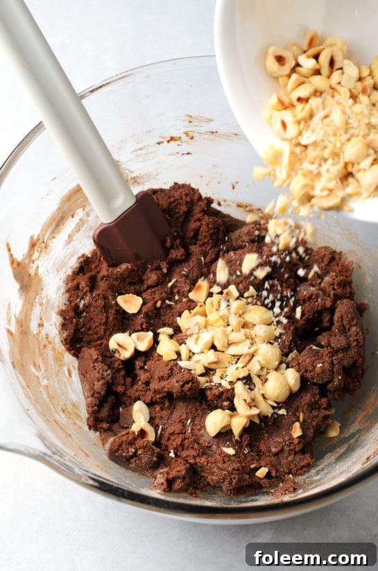 Folding in crushed hazelnuts into chocolate cookie dough