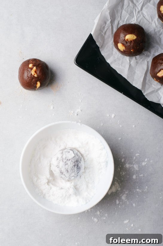 Cookies generously rolled in powdered sugar before baking