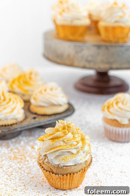 A vibrant display of completed Champagne Cupcakes, perfectly frosted and decorated with gold sprinkles, ready to be served.