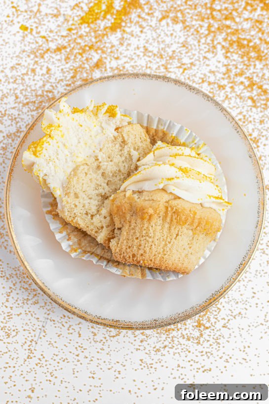Close-up view of a Champagne Cupcake sliced open, revealing its moist, tender crumb and champagne-infused flavor.