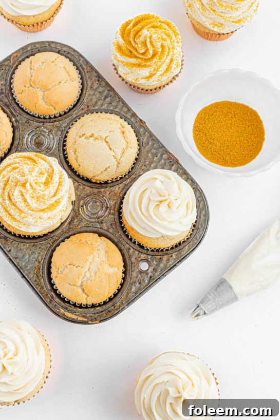 Detailed shot of frosting being applied to a Champagne Cupcake, creating a smooth and delicious buttercream topping.
