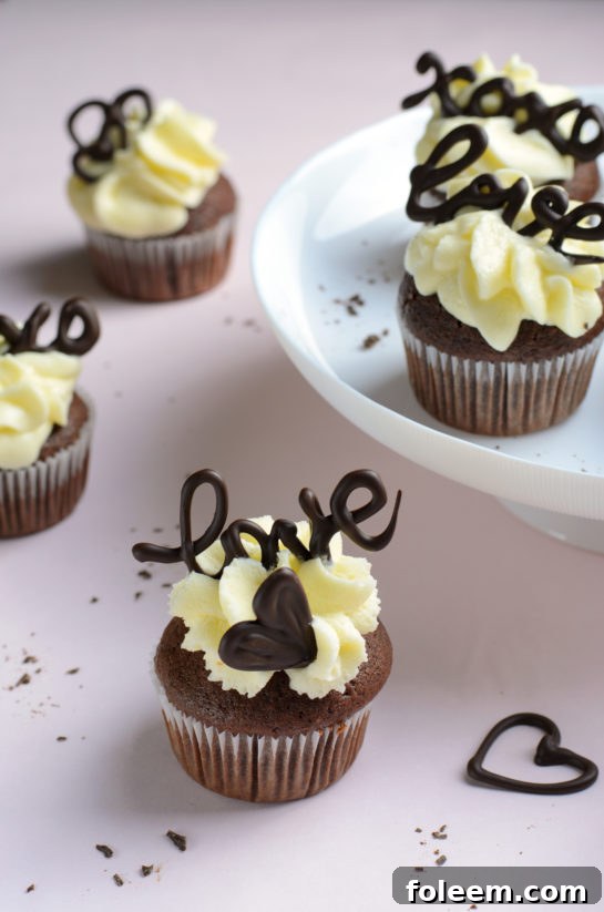 Finished Valentine's Day Lover's Chocolate Cupcakes topped with elegant chocolate lettering for a personal touch.
