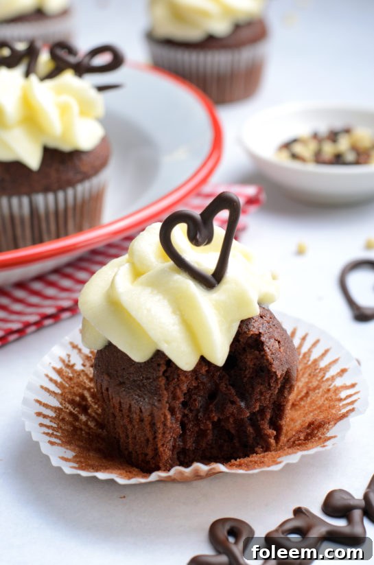 A delicious Valentine's Day Lover's Chocolate Cupcake with a bite taken out, revealing its fluffy interior.