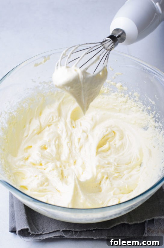 Smooth and creamy vanilla cream cheese frosting being prepared for Valentine's Day cupcakes.