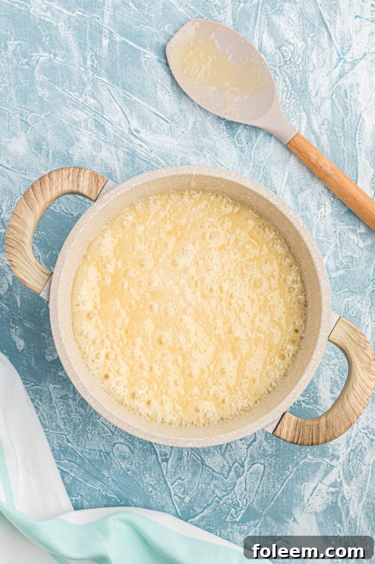 Boiling butter and sugar mixture for the easy Andes Mint Fudge recipe.
