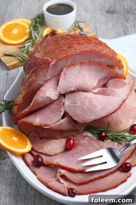 A perfectly glazed spiral ham, ready to be served, glistening with sweet glaze and adorned with festive garnishes, promising a delicious holiday meal.