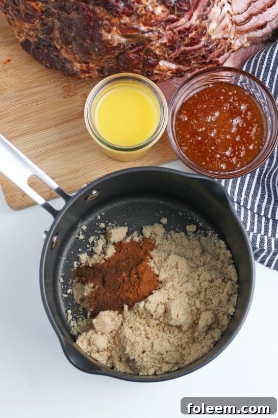 Ingredients for a homemade ham glaze, including brown sugar, honey, and orange juice, perfectly measured and ready to be combined.