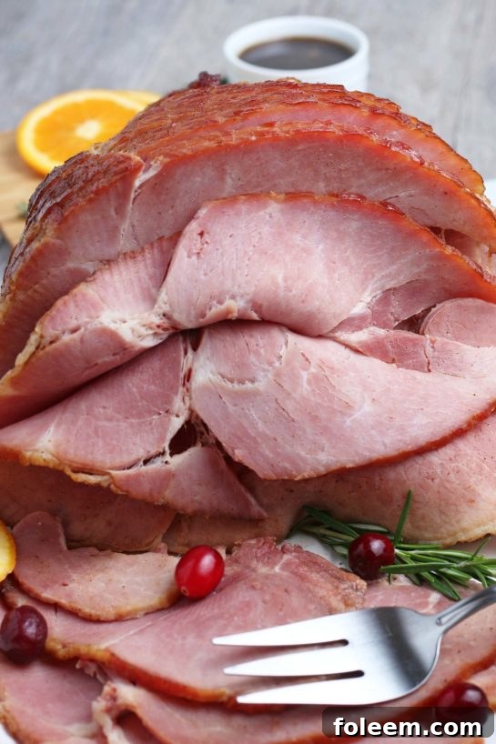 A close-up shot of a glazed spiral ham, beautifully cooked and ready for carving, with a golden-brown crust and juicy meat.