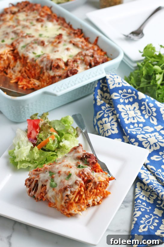 A single, inviting serving of Baked Million Dollar Spaghetti, showcasing its rich, creamy layers and generous cheese, perfectly plated and ready to enjoy.